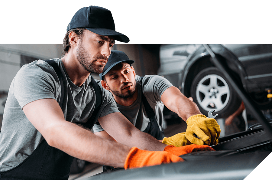 Two mechanics inspecting a car engine