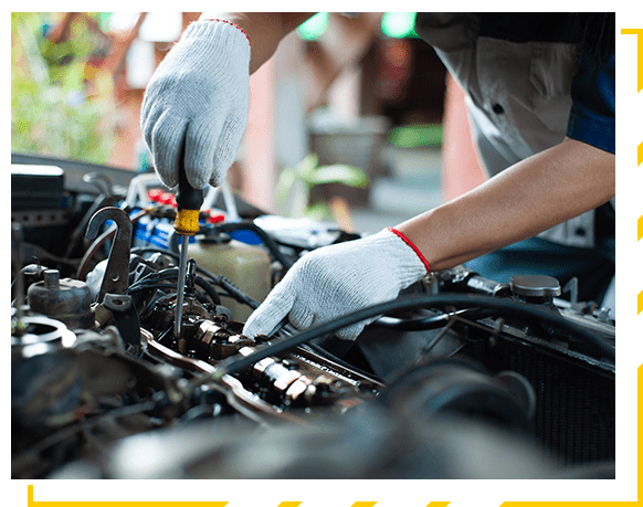 A mechanic is repairing a car about the engine's valve system.