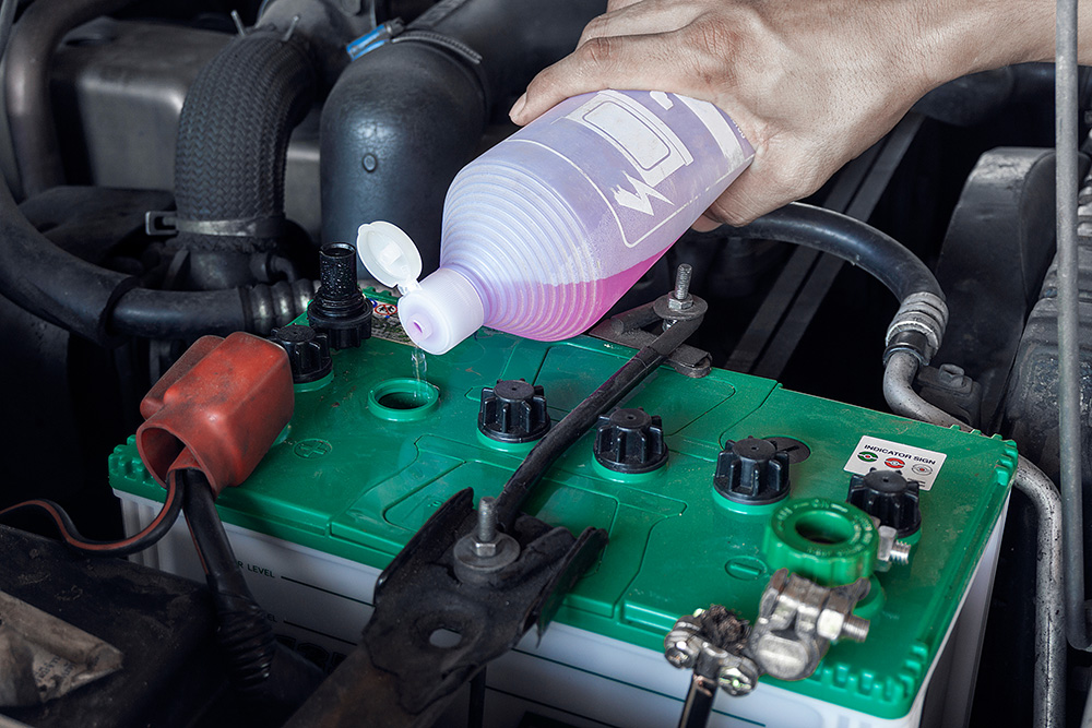 Mechanic Pouring Liquid to Vehicle Battery