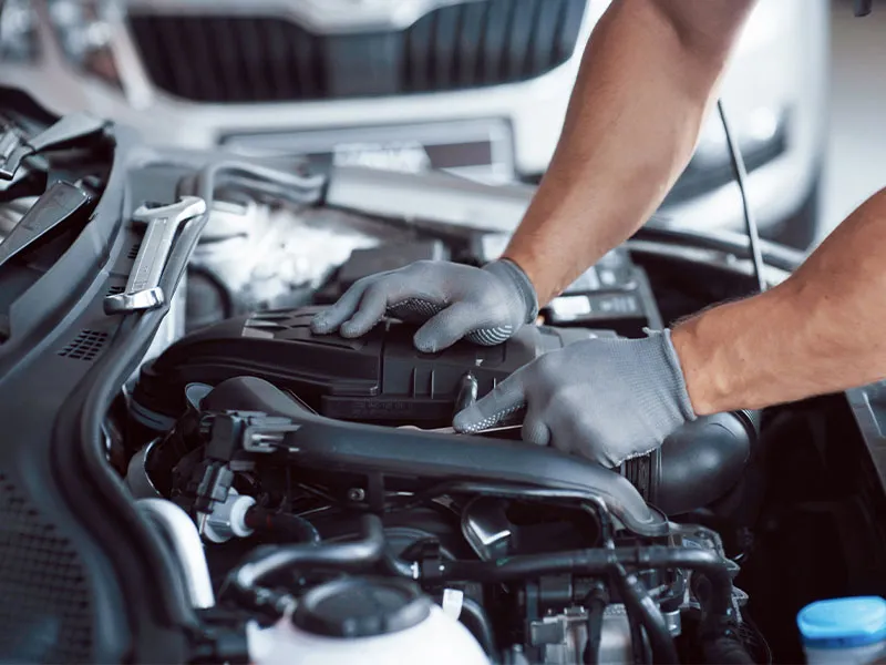 Auto mechanic working in garage. Repair service.