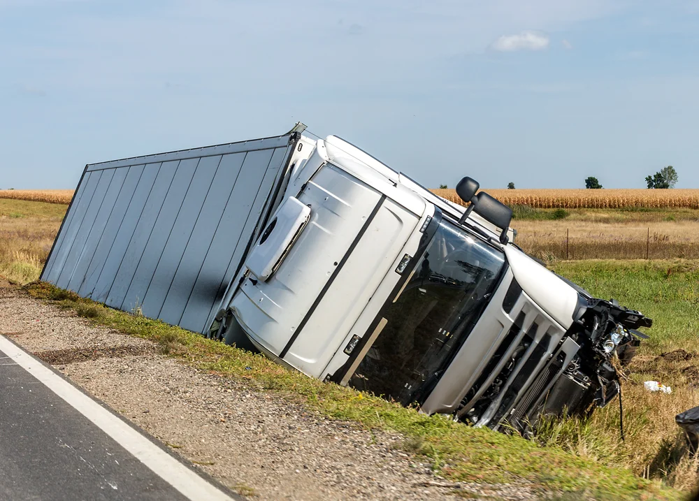 The large truck lies in a side ditch after the road accident