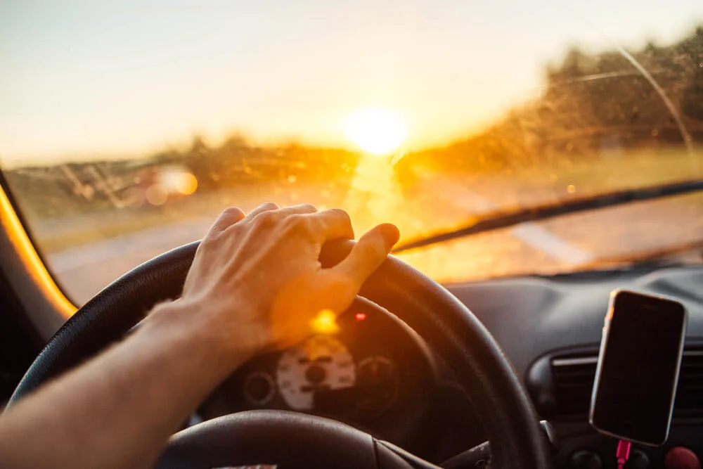 man driving with sunset background