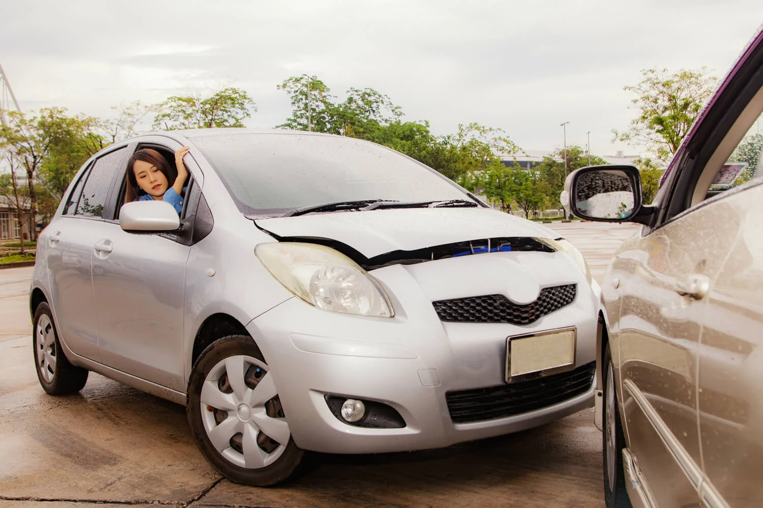 Accident during driving and car insurance concept : Beautiful Asian woman driving a bronze car gets into a road accident
