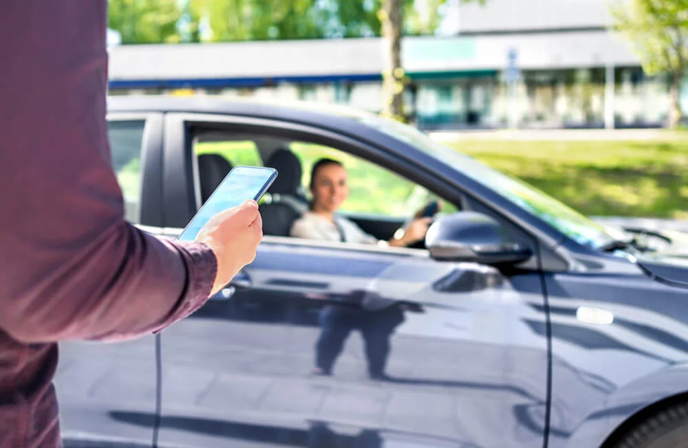 Taxi phone app for cab or car ride share service. Customer waiting driver to pick up on city street