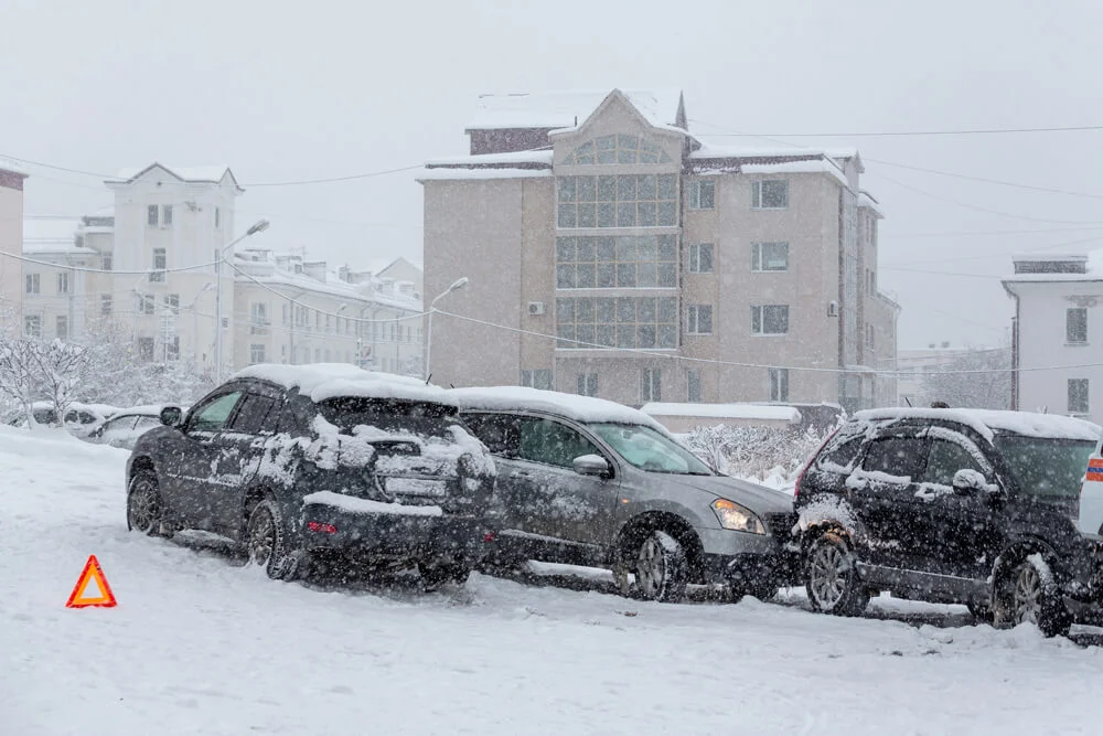 Car accident on a city street. Several cars crashed on a slippery snow-covered road