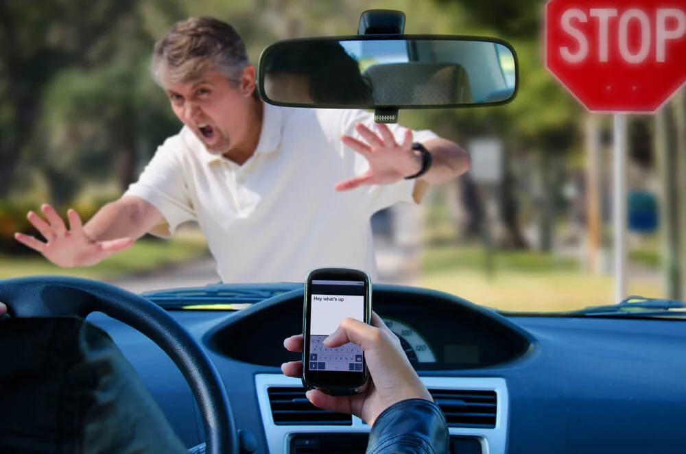 An irresponsible texting driver is about to run over a pedestrian at an intersection which shows how dangerous texting and driving is