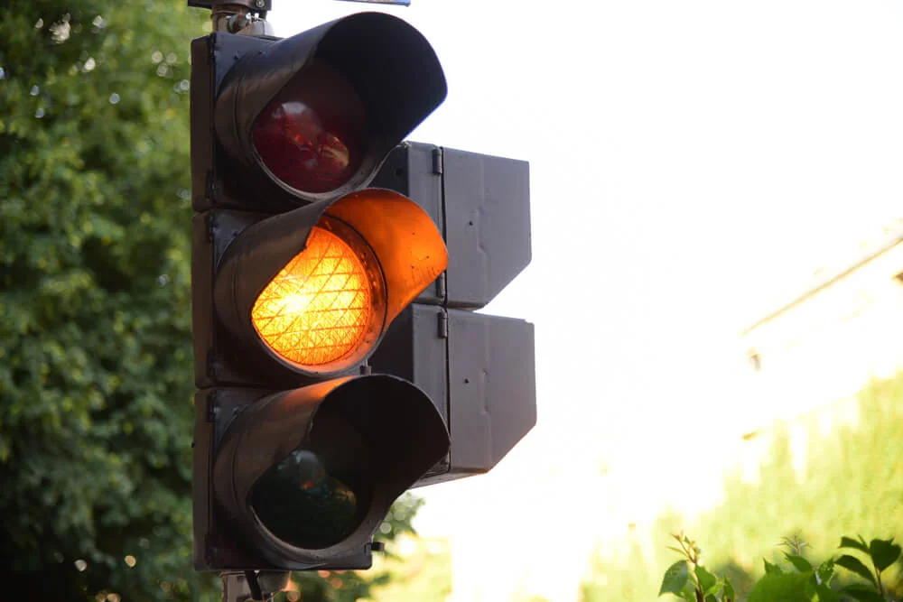 Yellow light of traffic lights in summer city