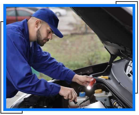 mechanic wearing blue hat and sleeve holding flashlight and screw