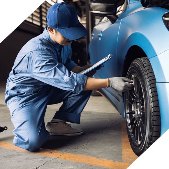 Mechanic inspecting car tire