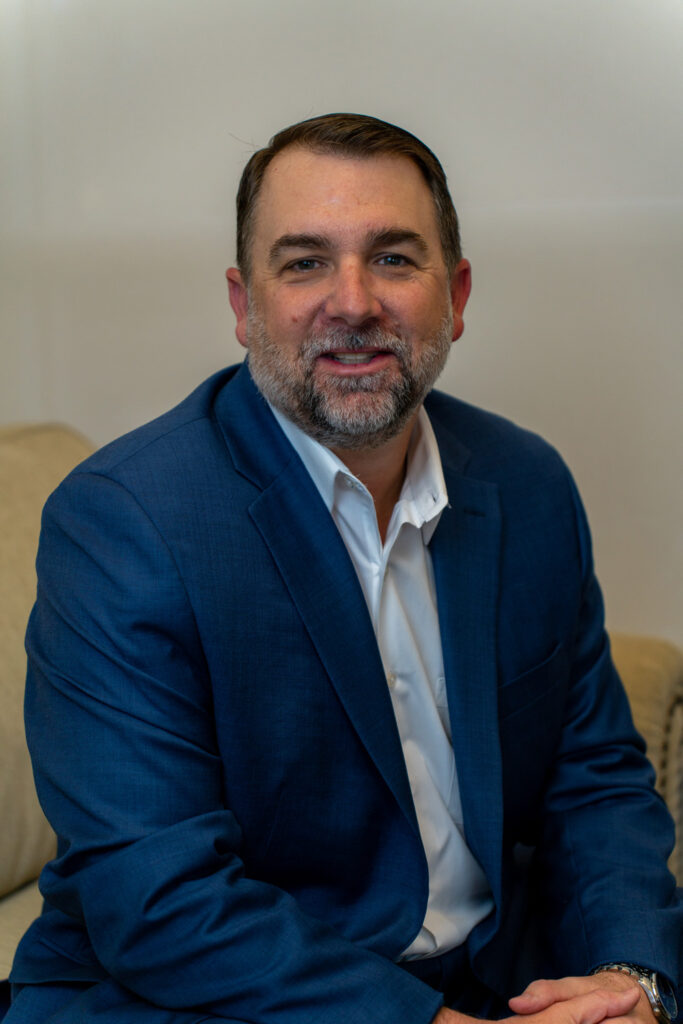 Man in a blue suit smiling at the camera