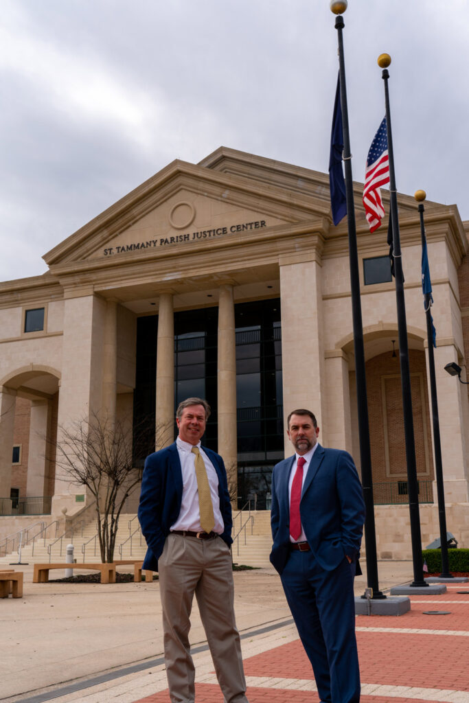 Two men in suits standing in front of St. Tammany Parish Justice Center