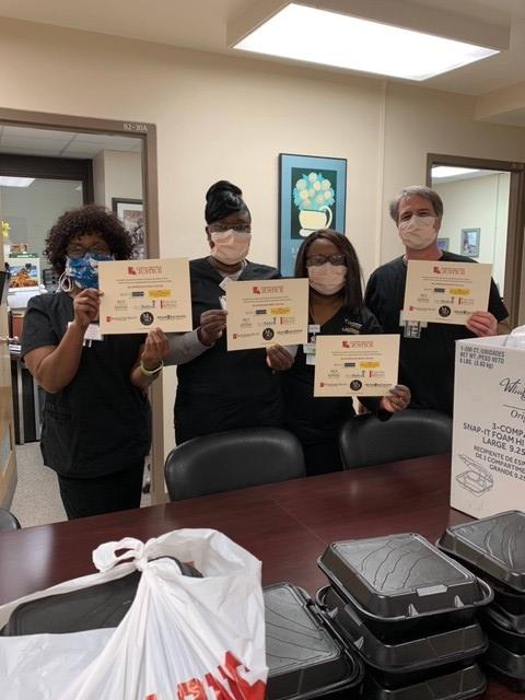 Staff of Morris & Dewett all wearing masks and holding certificates