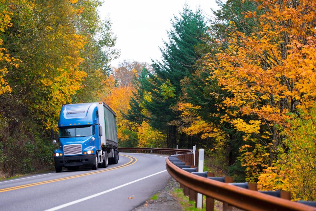 Truck driving on road in fall