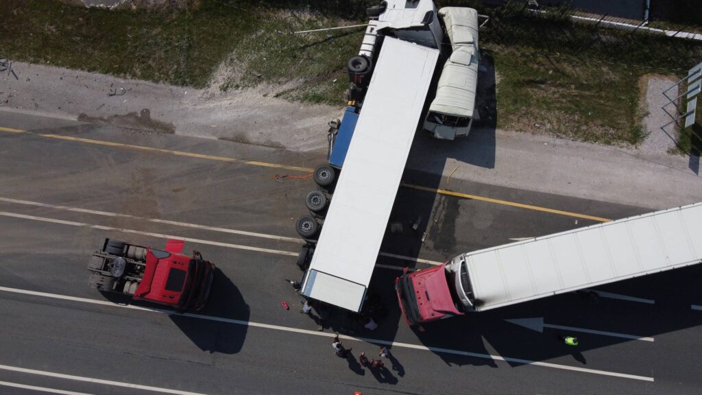 Top view of a car accident involving a truck and a bus.