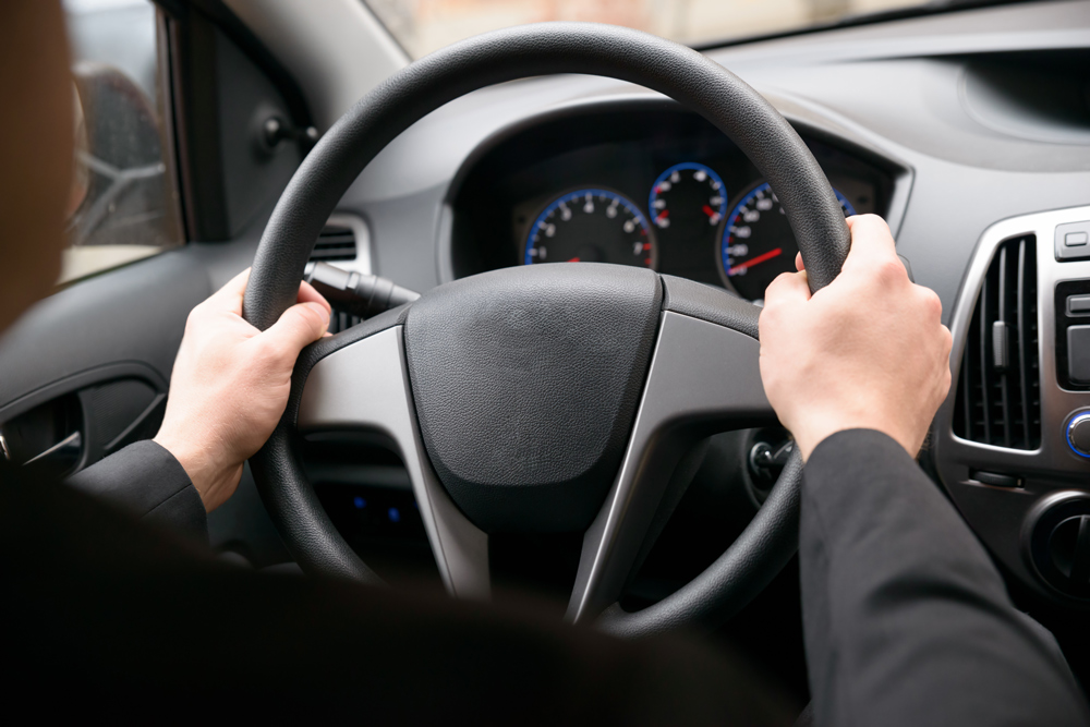 Close-up Of A Man Hands Holding Steering Wheel While Driving Car