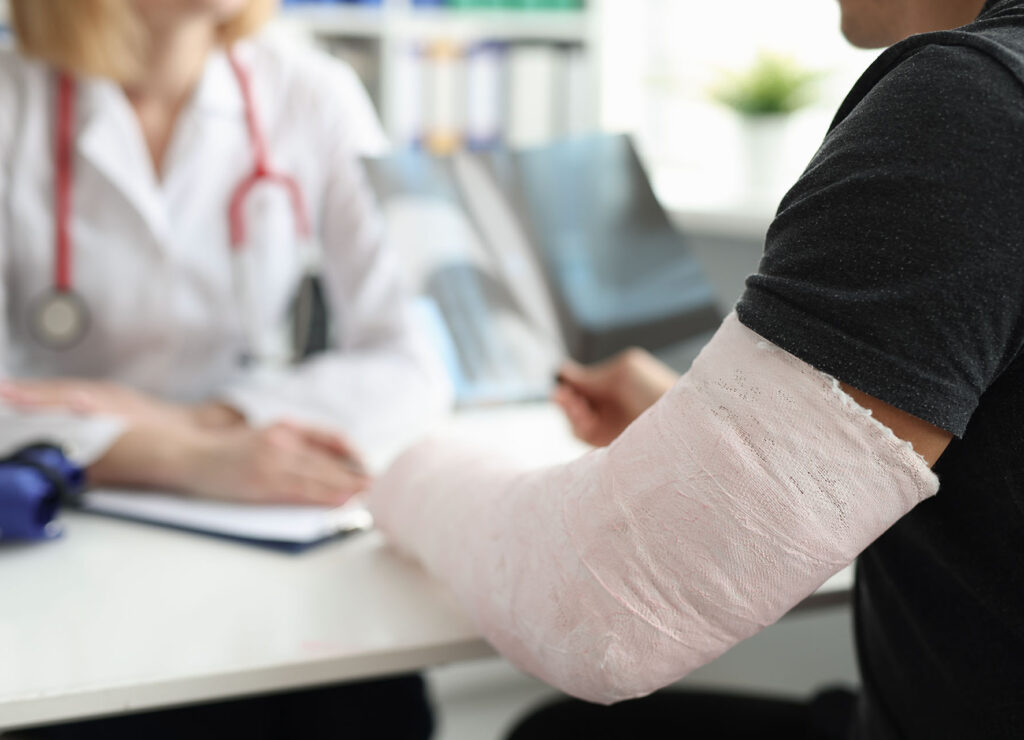 A man with a broken arm is sitting at the doctor