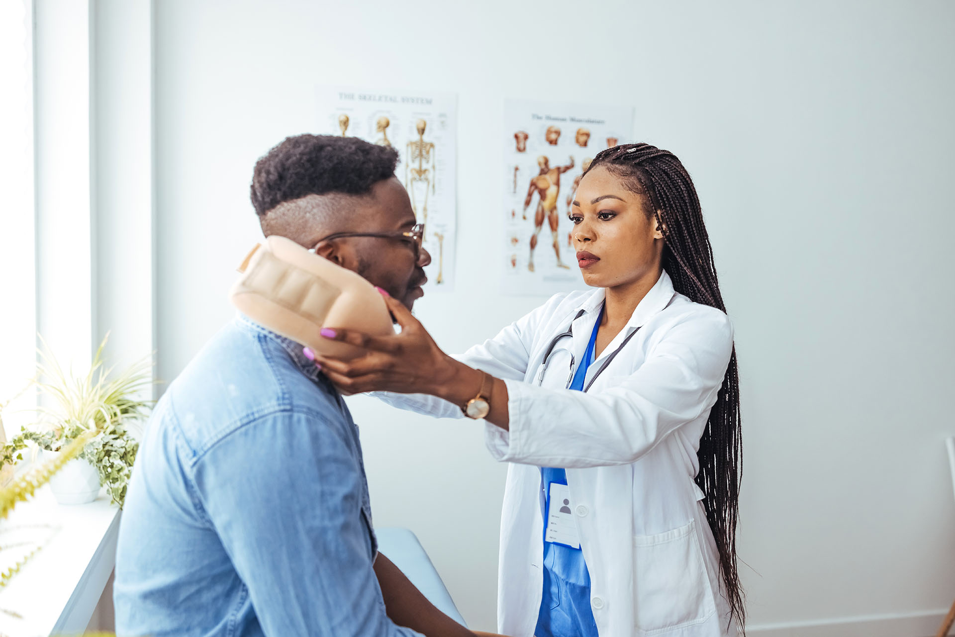 African American man wearing neck brace listening to doctor at hospital.