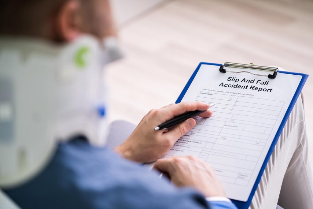Close-up Of A Businessperson With Broken Arm Filling Health Insurance Claim Form