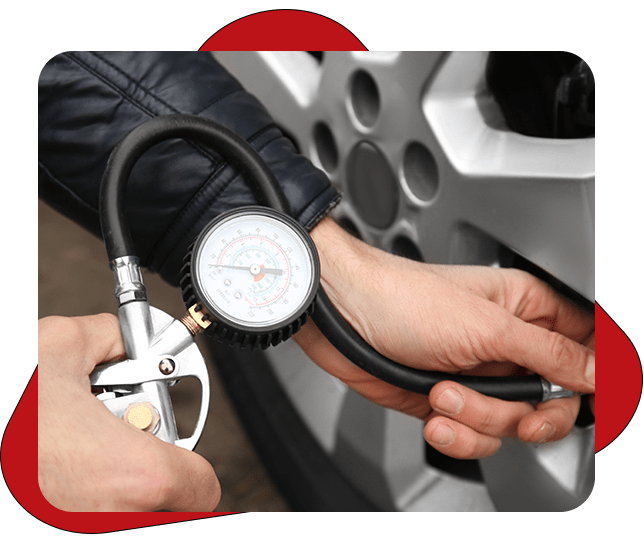 Auto mechanic checking tire pressure