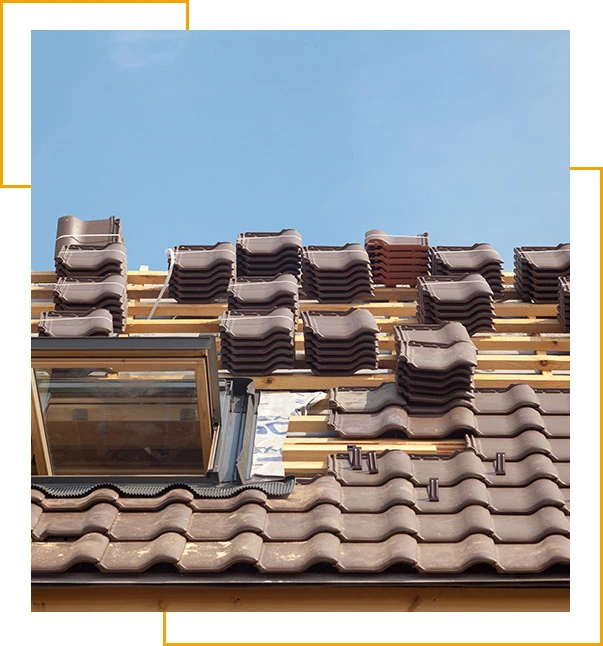 House under construction. Roofing tiles with open skylight